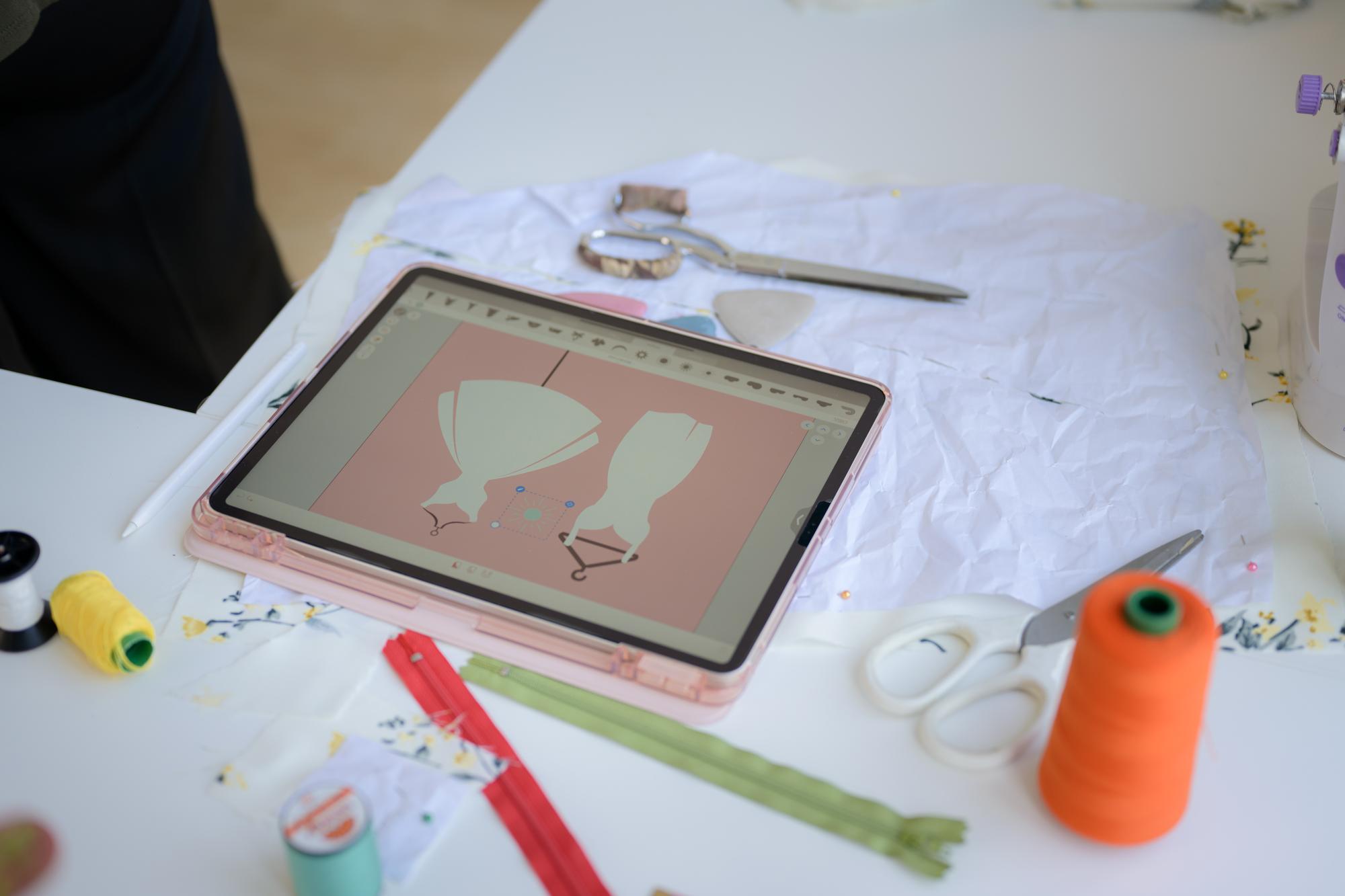 Studio workspace with embroidery machine and digital tablet
